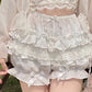 White Y2K shorts with multiple layers of lace and bows